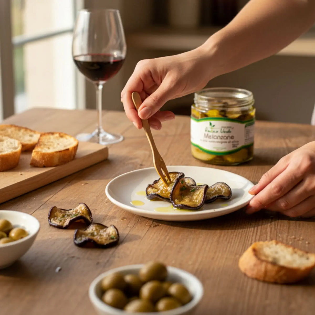 aperitivo con melanzane in olio extravergine di oliva, pane artigianale e un bicchiere di vino rosso Tintilia